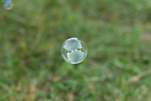 Soap ball in daylight against a background of greenery.