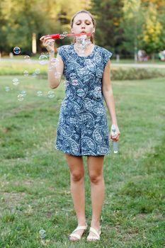 Beautiful girl in the park with soap bubbles.