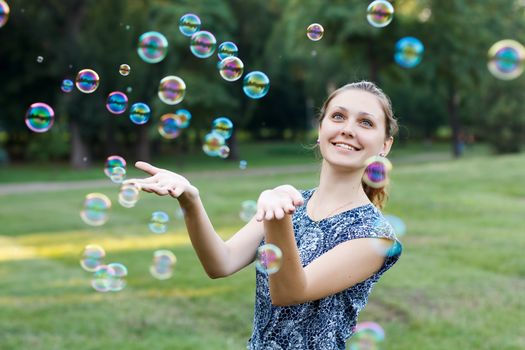 Beautiful girl in the park with soap bubbles.