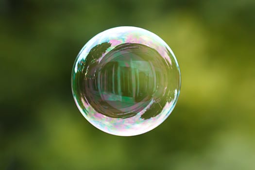 Soap ball in daylight against a background of greenery.