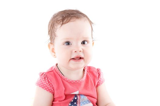 The girl is one year in dress sitting on a white background.