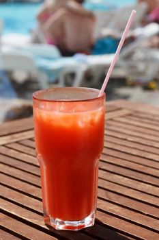 Cocktail with straw on the wooden table.