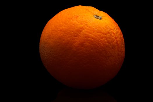 Photo of a ripe orange on a black background