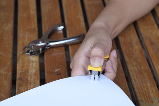 Hand hold stapler for binding sheets of paper closeup.