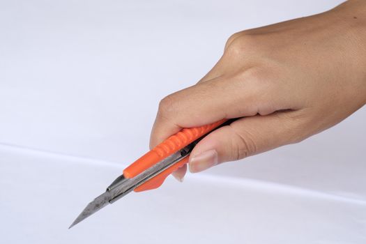 women hands cutting carton with a knife on a paper. Close up handwork.