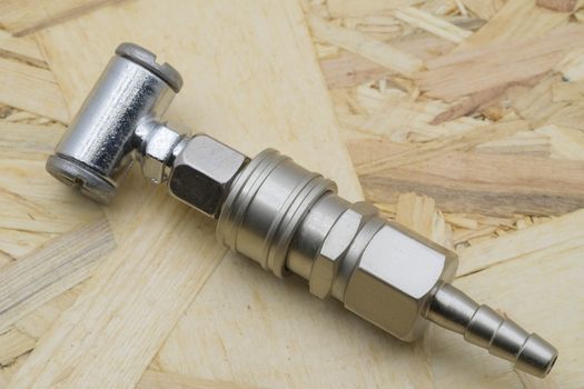 Air coupling connector, Pneumatic fitting on wood background.