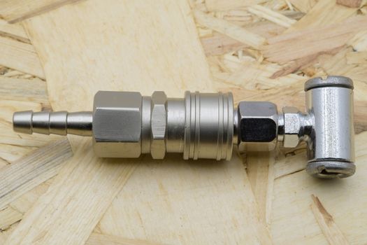Air coupling connector, Pneumatic fitting on wood background.