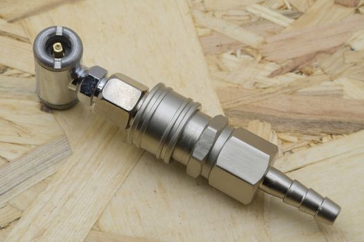 Air coupling connector, Pneumatic fitting on wood background.