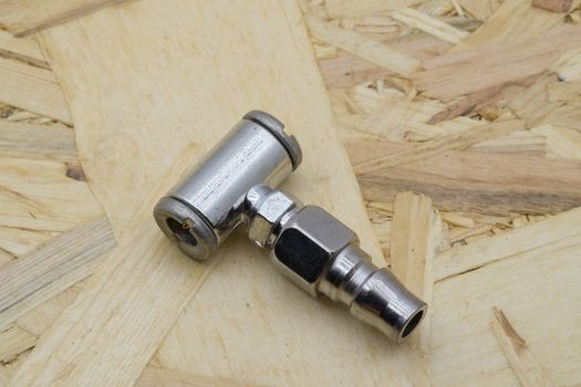 Air coupling connector, Pneumatic fitting on wood background.