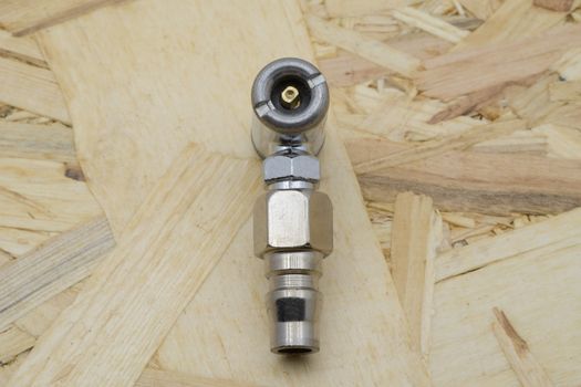 Air coupling connector, Pneumatic fitting on wood background.