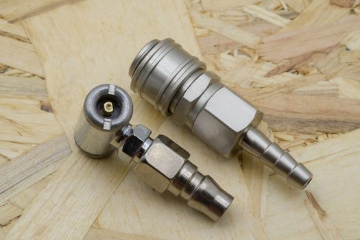 Air coupling connector, Pneumatic fitting on wood background.