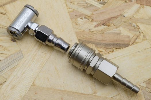 Air coupling connector, Pneumatic fitting on wood background.