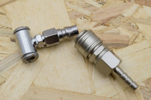 Air coupling connector, Pneumatic fitting on wood background.