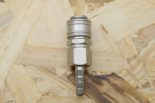 Air coupling connector, Pneumatic fitting on wood background.