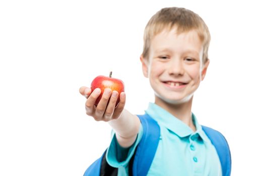 apple in focus in schoolboy's hand close-up