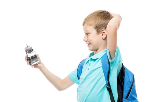 surprised schoolboy looking at alarm clock on white background