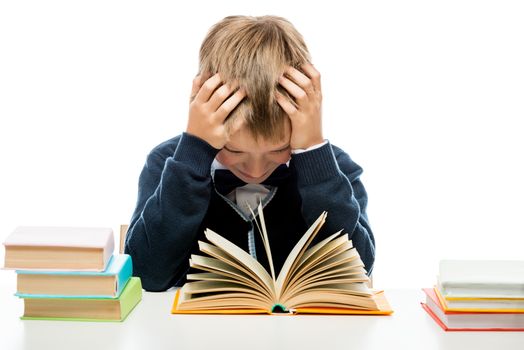 tired schoolboy with books sitting at table, portrait isolated