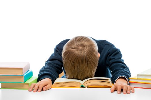 a schoolboy at a table at a table fell asleep while reading, shooting in a studio