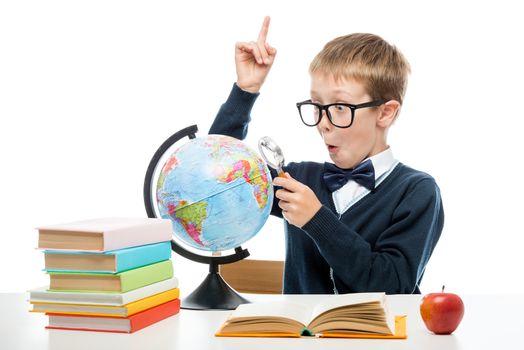 schoolboy with a magnifying glass opened new horizons staring into the globe