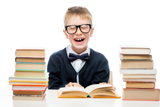 schoolboy wearing glasses with books for reading at a table on a white background