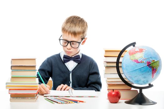 boy student at the table alone doing homework on a white background