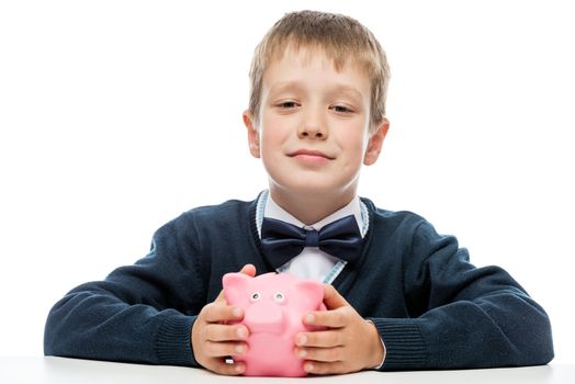 happy successful boy holding a piggy bank pink