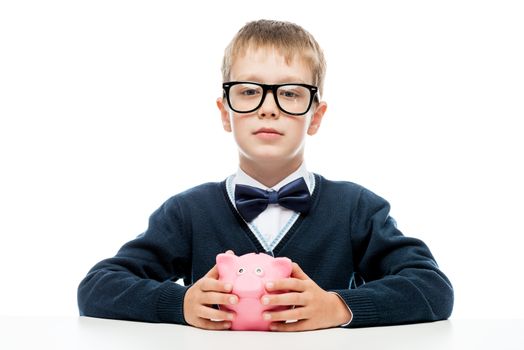 portrait of a successful boy with a piggy bank pink on a white background