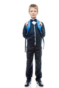 vertical portrait of a schoolboy with a backpack in the form in full length isolated