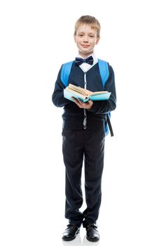 happy schoolboy with textbook and backpack on a white background in full length isolated