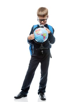 schoolboy examines through magnifier glass globe, portrait is isolated in full length on a white background