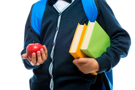 close-up in the hands of a schoolboy apple and textbooks