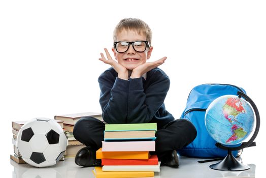 horizontal portrait of a joyful schoolboy with books and globe on a white background in studio