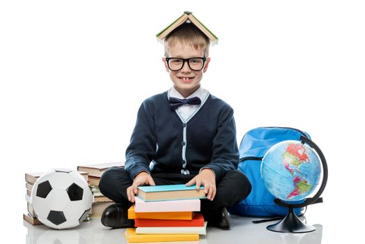 joyful schoolboy with books and globe on white background in studio