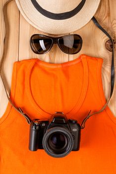 the image of a tourist photographer from clothes and accessories on wooden boards view from above