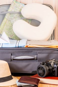 vertical photo of objects for travel near the suitcase