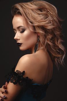 Studio Portrait of a young gentle sexy model girl with stylish makeup on a dark background