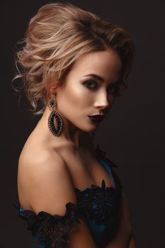 Studio Portrait of a young gentle sexy model girl with stylish makeup on a dark background