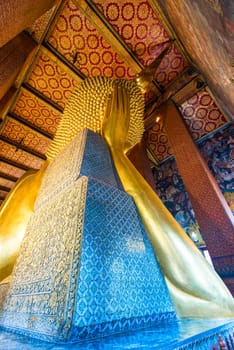 view from the back of gold lying Buddha in a temple in Bangkok