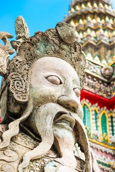 face of a stone guard - sculpture on the background of a temple, Bangkok, Thailand