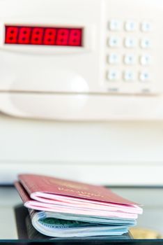Passports of travelers and money on the background of the safe in the hotel