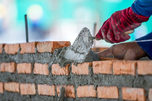 construction worker laying bricks and building in construction site