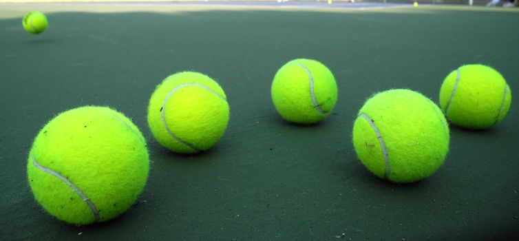 Group of six tennis balls on tennis court