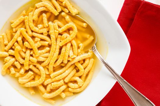 Closeup of Italian passatelli in broth seen from above