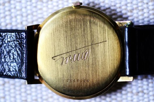Back of the hand golden clock with Tito's signature