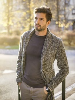 One handsome young man in urban setting in European city, standing