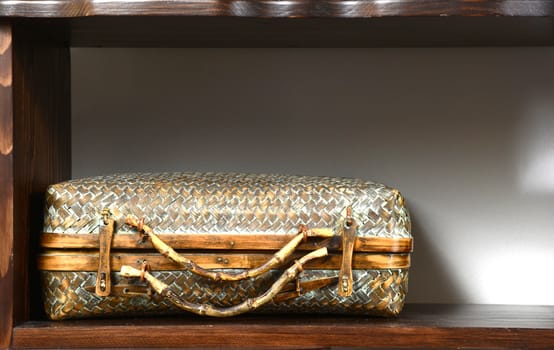 Old rustic wooden suitcase on wooden shelf