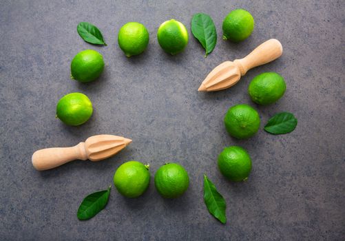 Fresh limes and wooden juicer on white background. Top view with copy space