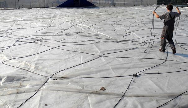 Worker with a lot of cables on construction site