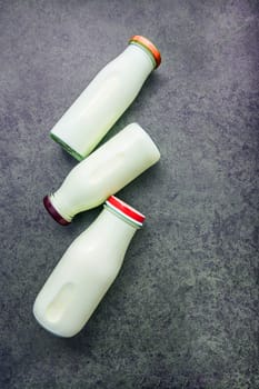 Milk bottle on dark stone background. Top view with copy space.