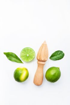 Fresh limes and wooden juicer on white background. Top view with copy space